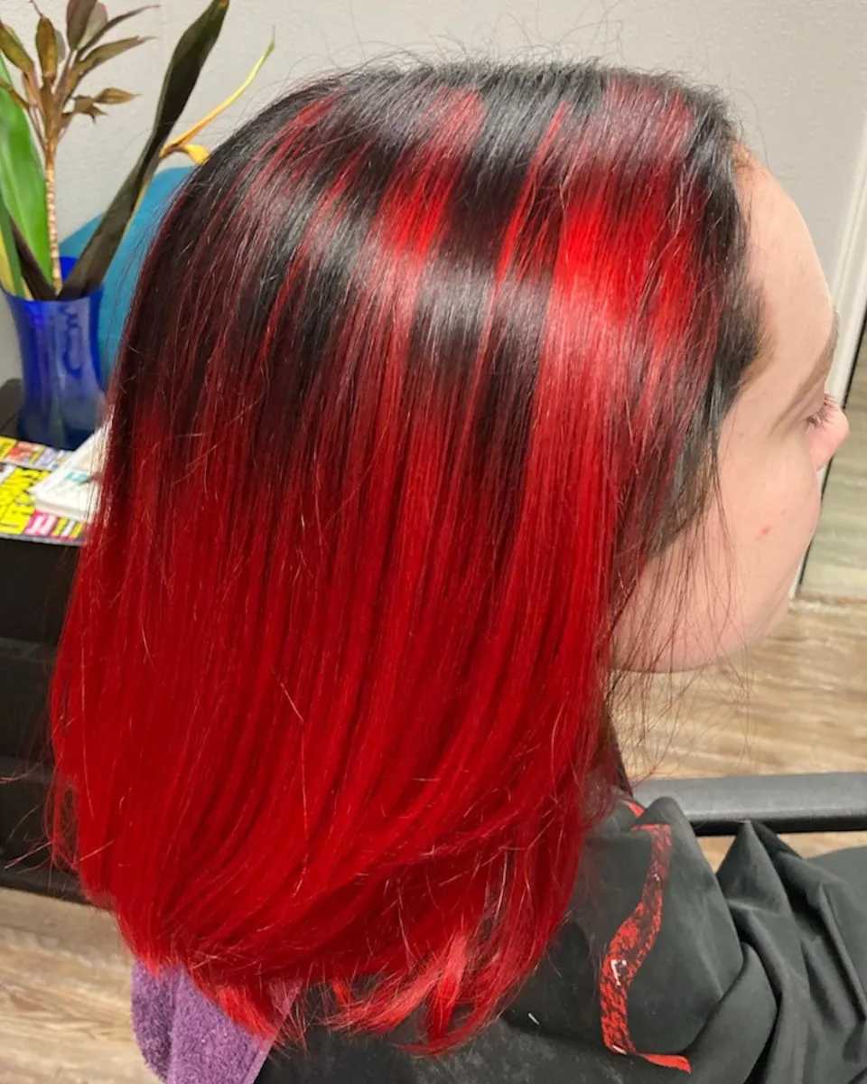 Glossy red balayage on long waved hair